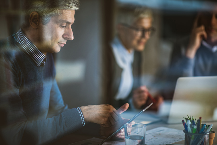 Man on tablet with colleagues in background