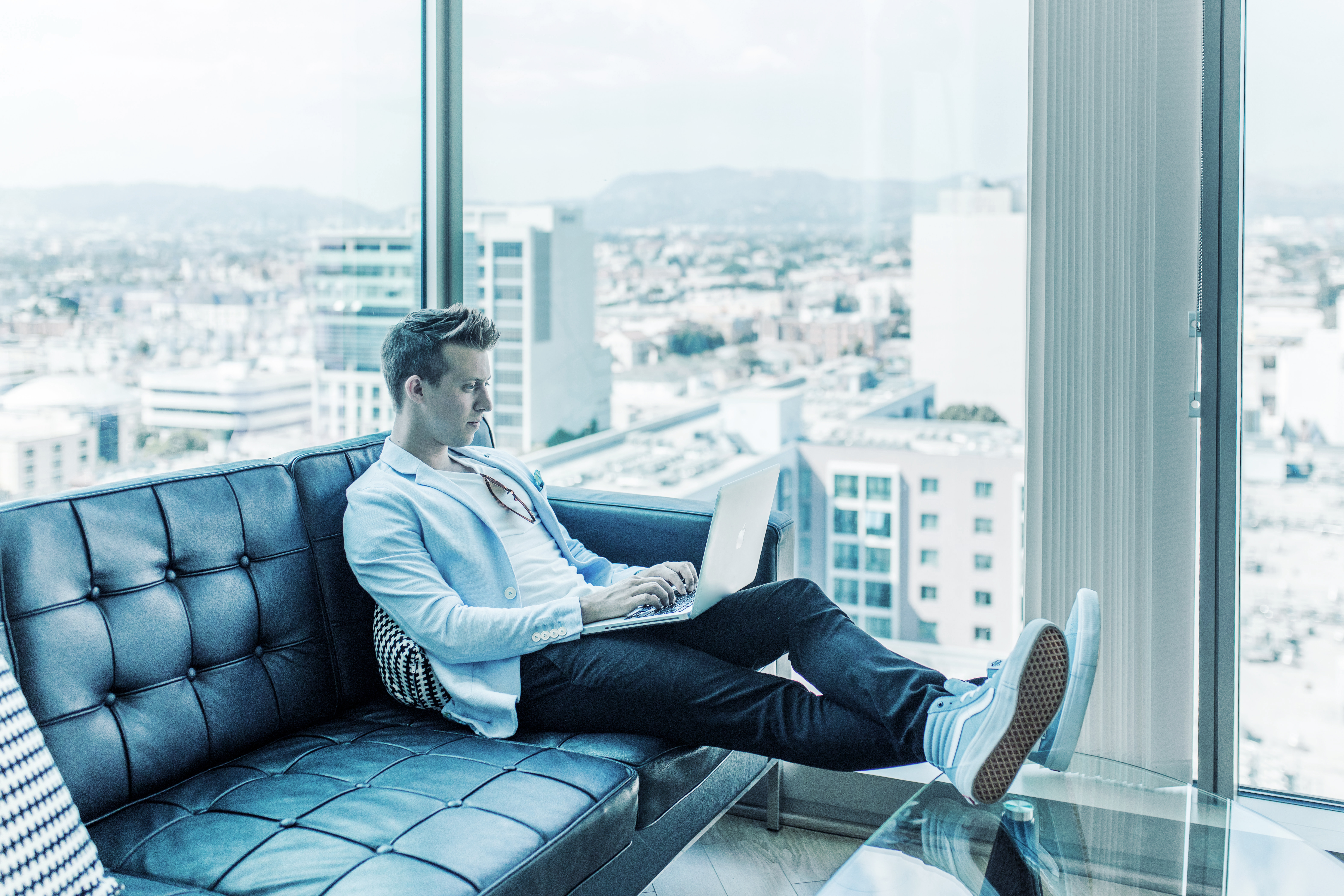 Man typing while sitting on a couch